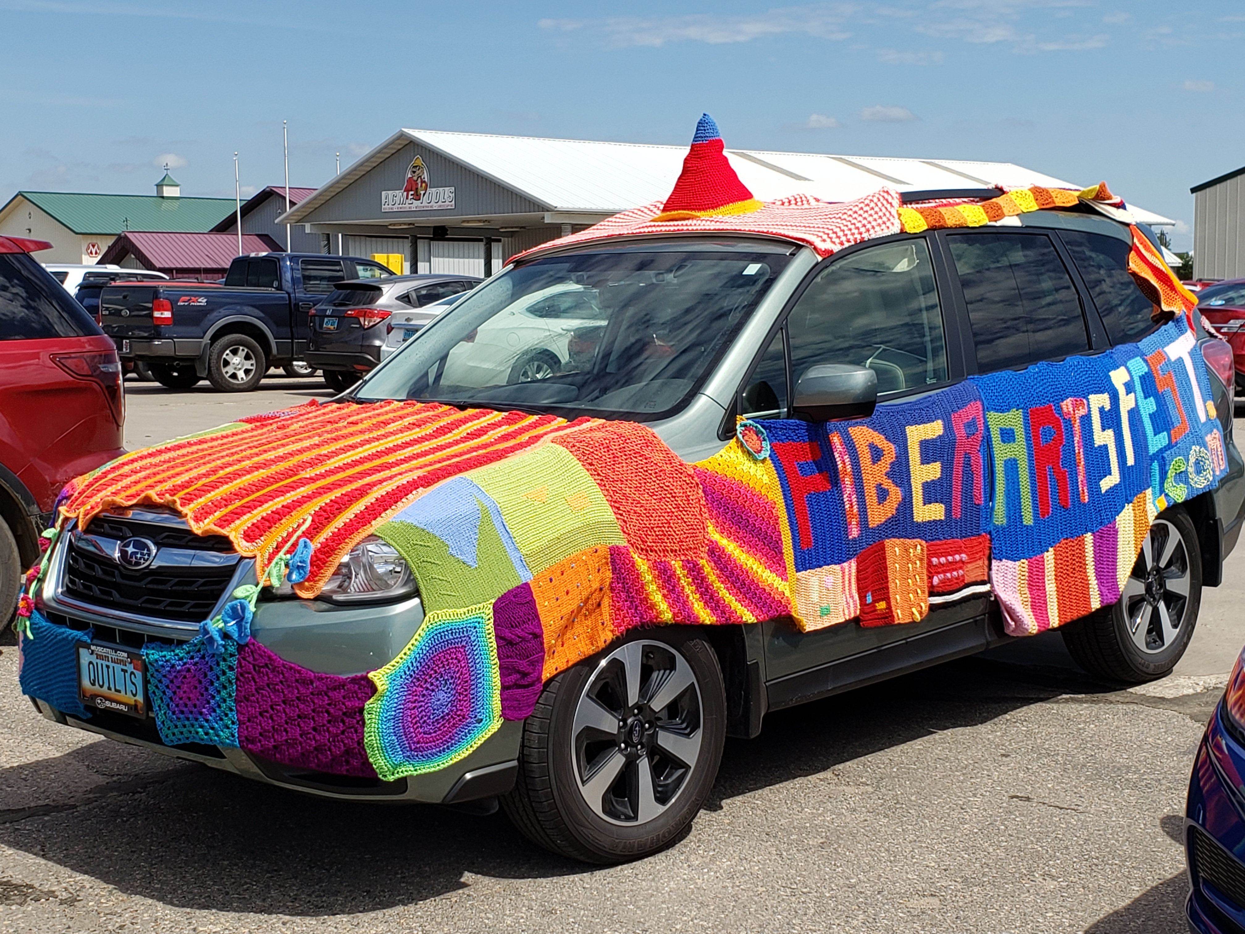 Subaru car 'quilted' with material and the brand 'fiberartsfest.com'